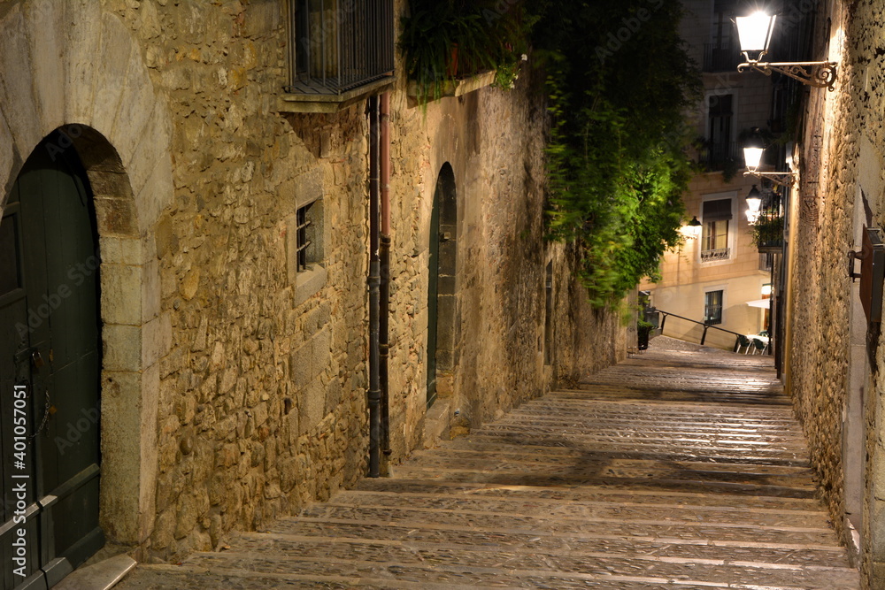 Fototapeta premium Calle estrecha y empedrada del antiguo barrio judio, del casco antiguo de la ciudad de Girona, en el norte de Catalunya
