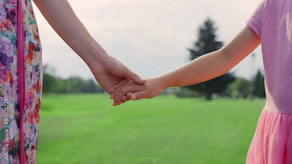 Unknown woman holding girl hand outdoor. Closeup mother and daughter hands. Unknown woman holding girl hand outdoor. Closeup mother and daughter hands.