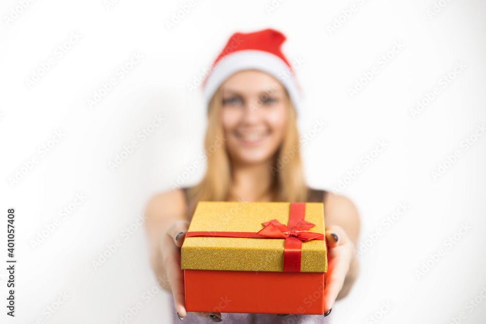 A glamorous young woman holds a Christmas present in her hands. A wonderful female model is preparing for a new year's party A glamorous young woman holds a Christmas present in her hands. A wonderful female model is preparing for a new year's party