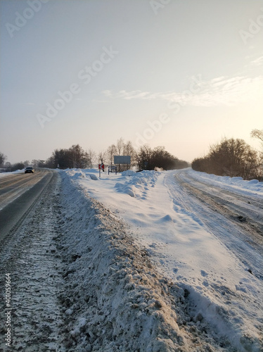 Winter landscape. A road covered with white snow. The car is driving along the road