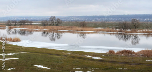 Fototapeta Naklejka Na Ścianę i Meble -  Spring panorama of a calm river. Melting ice on the river.