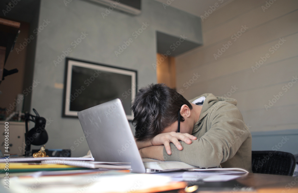 tired young boy leaning on the computer tired young boy leaning on the computer