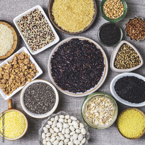 Food background of various cereals and grains in plates on a canvas