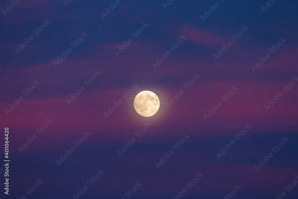 Yellow full moon with glow in the sky with purple clouds Yellow full moon with glow in the sky with purple clouds
