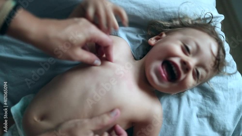 Parent tickling baby boy toddler. Adorable one year old child being tickled
