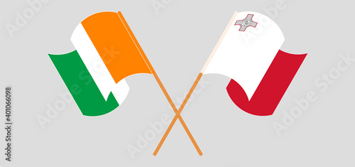 Crossed and waving flags of Malta and Republic of Ivory Coast