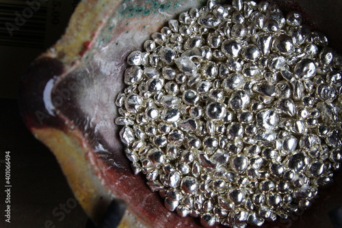 A ceramic crucible or melting pot with grains of sterling silver 925 for jewelry making after hand smelting in a workshop. One of the two major precious metals on the market.