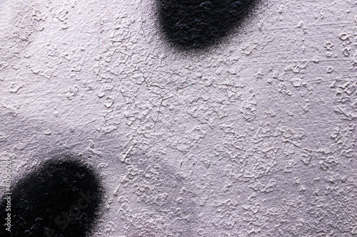 A white old rough wall with black round spots of paint. Empty template and mockup. 