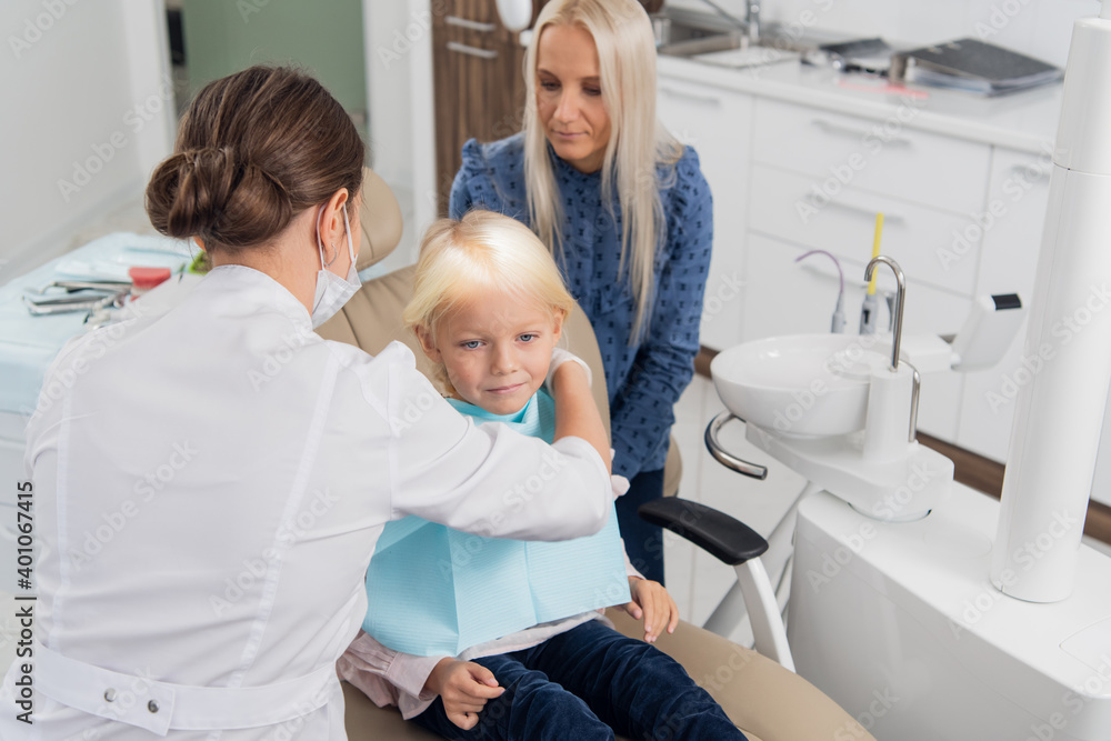 A doctor is preparing the little blond girl for the dental check up. A doctor is preparing the little blond girl for the dental check up.