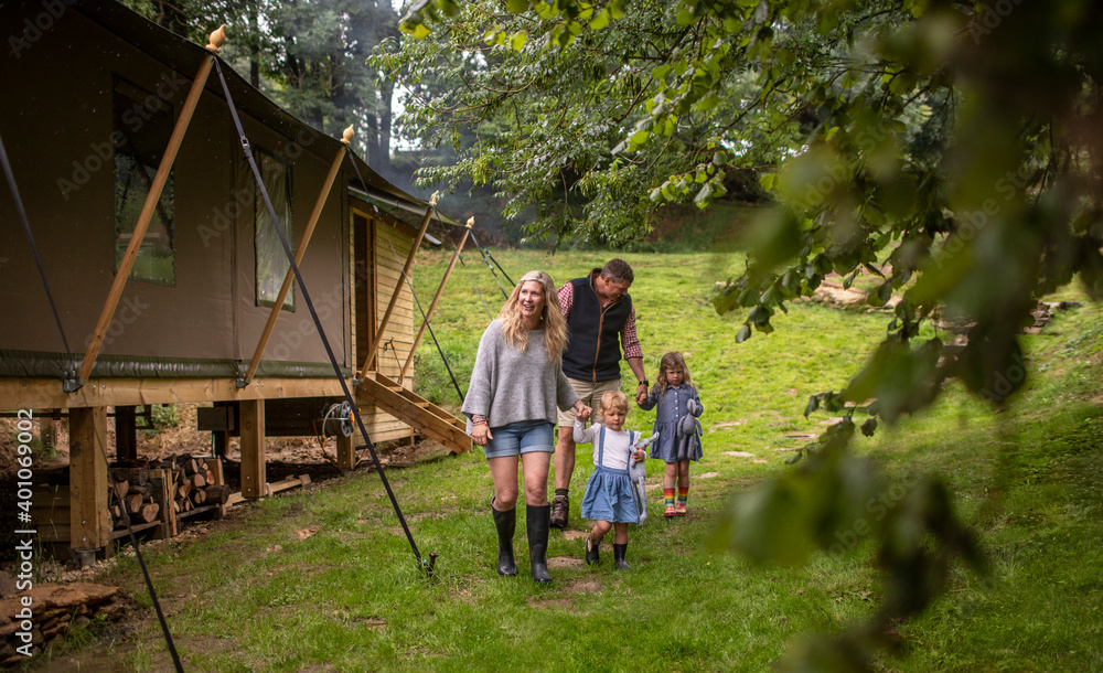 Family walking outside cabin in woods Family walking outside cabin in woods