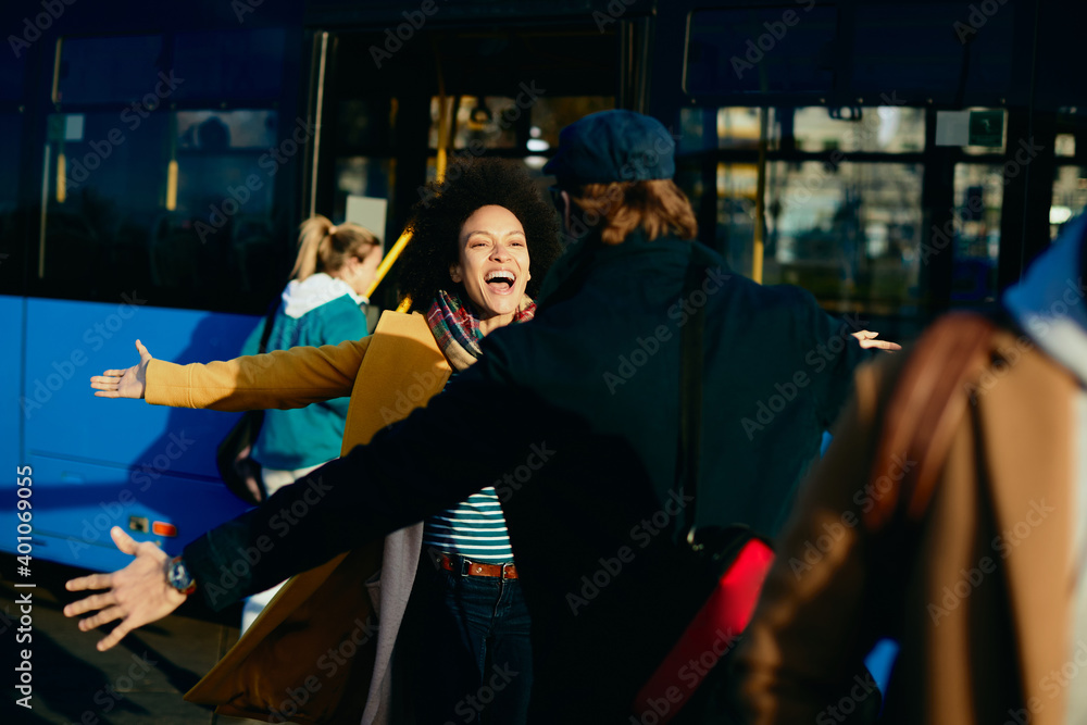 Cheerful African American woman meeting with her boyfriend at bus station. Cheerful African American woman meeting with her boyfriend at bus station.
