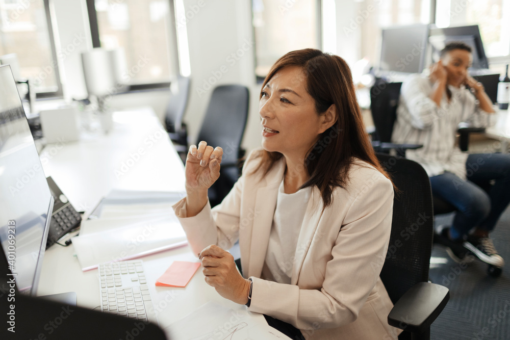 © Paul Bradbury/Caia Image - Businesswoman working at computer in office