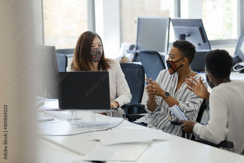 Business people in face masks talking in office meeting Business people in face masks talking in office meeting