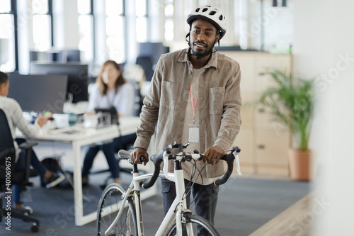 Businessman walking bicycle in office photo