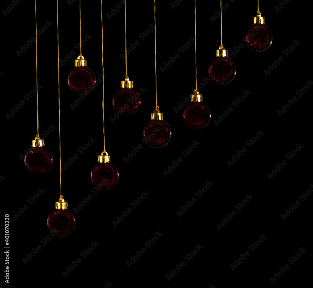 Red christmas balls hanging on golden threads isolated on black background Red christmas balls hanging on golden threads isolated on black background