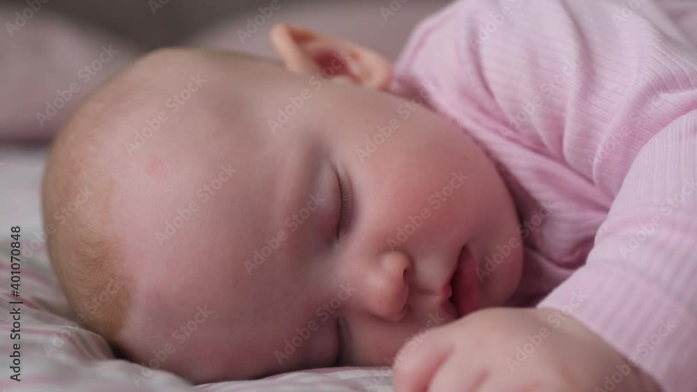 Close-up face of beautiful caucasian sweet newborn baby sleeping in bed. Concept of care happy family and child children baby parenthood childhood, Little nice girl lying on bed sleeping in room Close-up face of beautiful caucasian sweet newborn baby sleeping in bed. Concept of care happy family and child children baby parenthood childhood, Little nice girl lying on bed sleeping in room
