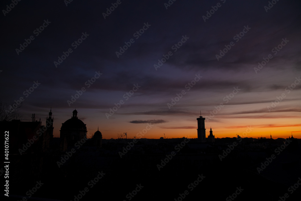 Europe city church dome and historical tower building silhouette evening sunset sky background scenic view dark purple color clouds and empty copy space for your text here