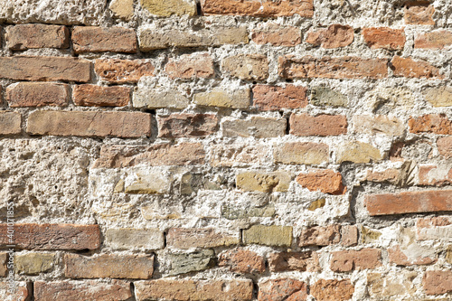 brick wall with structure of white, grey and brown stones, sunny day with shadows on the stones background, space for text and no person