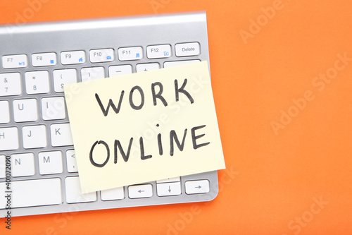 Inscription Work Online on paper with keyboard on orange background