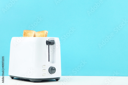 Toaster with toast bread on blue background