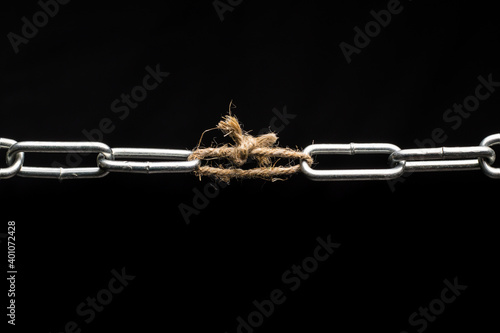 The chain is tied together with a rope. Weak link in the chain. photo