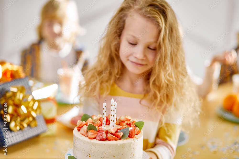 child girl holding birthday cake in hands, kids friends gathered to celebrate her birthday, cute girl enjoys the time with friends, happy