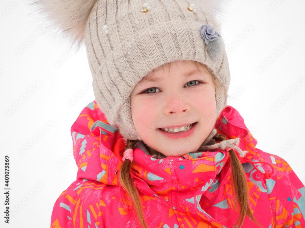 Cute child girl playing on a winter walk in nature. A close up portrait of a little pretty charming smiling girl in a knitted hat in a frosty winter day outdoor. Cute child girl playing on a winter walk in nature. A close up portrait of a little pretty charming smiling girl in a knitted hat in a frosty winter day outdoor.