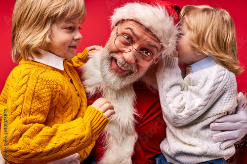 santa claus talking having fun with kids, children sharing secrets and their wishes, wants their dreams come true