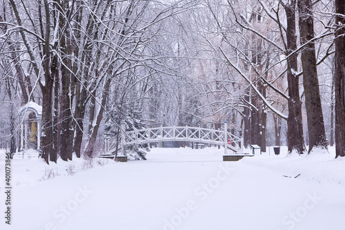 Pretty white Maizerets Domain pedestrian bridge over narrow river in the Limoilou neighbourhood seen during a grey winter day, Quebec City, Quebec, Canada photo