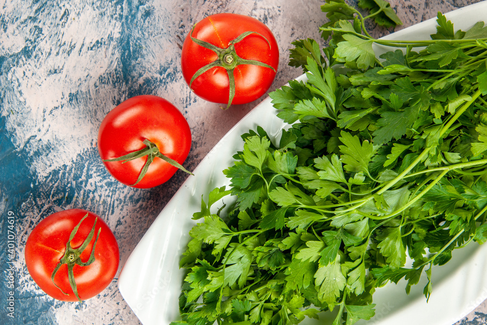 top view fresh greens with tomatoes on a light-blue background ripe salad photo meal color top view fresh greens with tomatoes on a light-blue background ripe salad photo meal color
