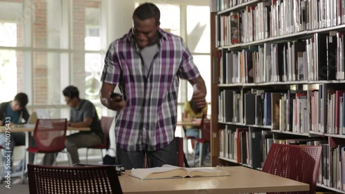 Man in library dancing to good news on cell phone photo