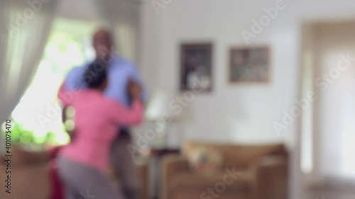 Defocused shot of middle-aged Black couple dancing in livingroom photo