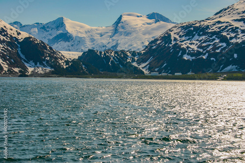 Sunlight glistening on the water of Prince William Sound in Alaska ringed by the steep and glaciated Chugach Mountains. It was named after Prince William Henry, son of King George III.  photo