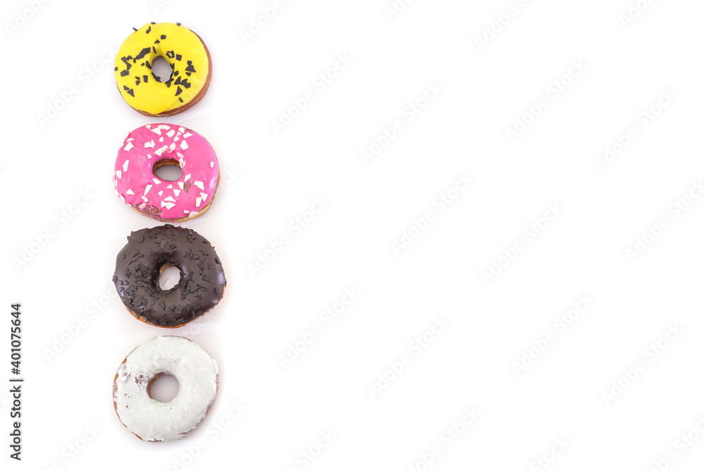 Fototapeta premium row of traditional American donuts with chocolate, pink, yellow, white icing and sprinkles isolated on white background. Copy space.