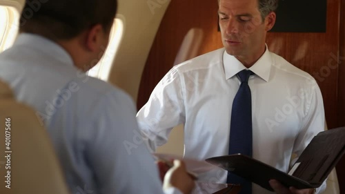 Businessmen discussing paperwork on private jet photo