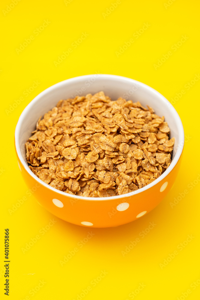 flakes wheat in the bowl on yellow background flakes wheat in the bowl on yellow background