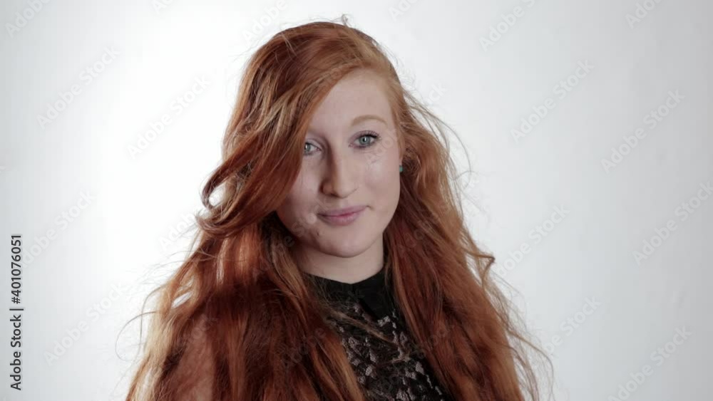 Portrait of smiling woman with red hair blowing in wind Portrait of smiling woman with red hair blowing in wind