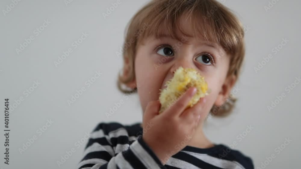 Toddler eating corn cob. One year old baby child healthy snacking Toddler eating corn cob. One year old baby child healthy snacking