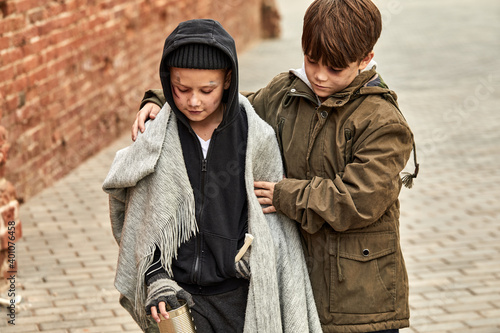 Canvastavla two despaired street boys support each other, begging in city streets, at cold w
