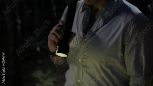 Friends examining map with flashlight in woods at night photo