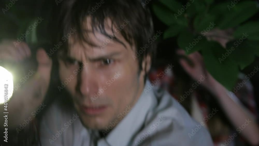 Close up of cautious friends walking in woods at night with flashlight Close up of cautious friends walking in woods at night with flashlight