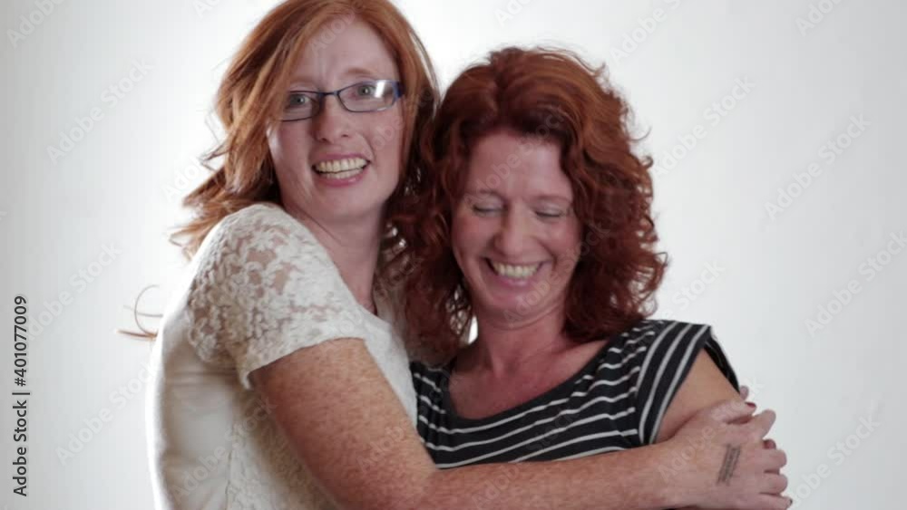 Portrait of twin sisters with red hair hugging Portrait of twin sisters with red hair hugging
