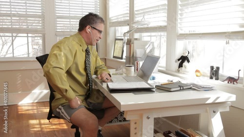 Mixed race businessman working on laptop in home office photo