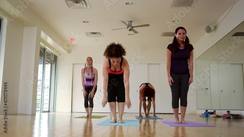 Women performing yoga poses during yoga class in studio photo