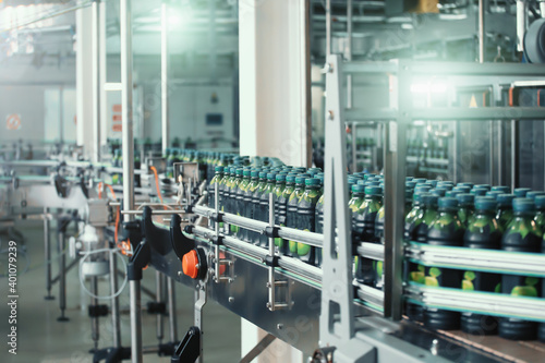 Industrial beverage factory interior. Conveyor with packaging of bottles with juice.