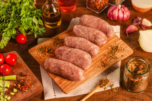 Brazilian pork sausage with chimichurri on wood cutting with spices and ingredients