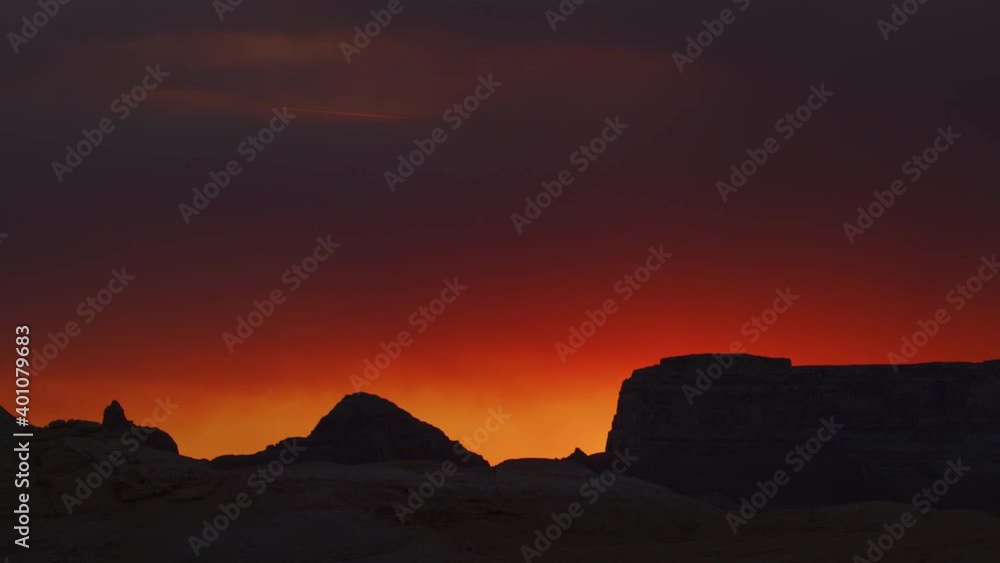 Smoke over silhouette of rock formation under dramatic sky at sunset / Glen Canyon National Park, Utah, United States Smoke over silhouette of rock formation under dramatic sky at sunset / Glen Canyon National Park, Utah, United States