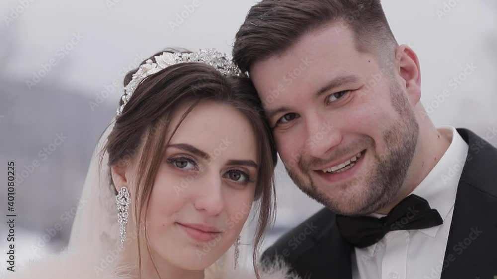 Groom and bride walking in glasses tunnel. Happy newlyweds on their wedding day. Outside is winter Groom and bride walking in glasses tunnel. Happy newlyweds on their wedding day. Outside is winter