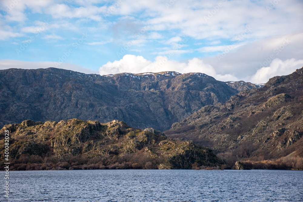 Unique horizontal view from a boat in the middle of a lake with calm water and a snow-capped mountain in the background Unique horizontal view from a boat in the middle of a lake with calm water and a snow-capped mountain in the background