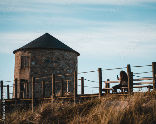 Lady reading a book at the beach in Apúlia, Braga, Portugal